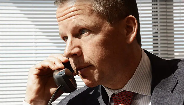 A man in a suit and tie talking on the phone.